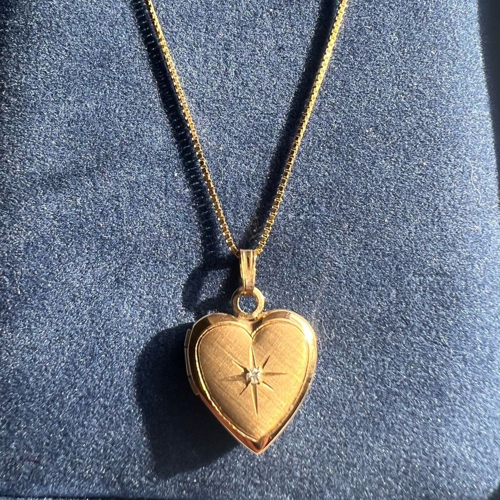 14K yellow gold necklace with heart-shaped locket and diamond